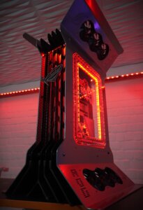 MP-Customized에서 제작한 미래적인 타워형 디자인의 MAXIMUS 쇼케이스 PC가 붉은 조명 아래 측면에서 촬영된 모습입니다.